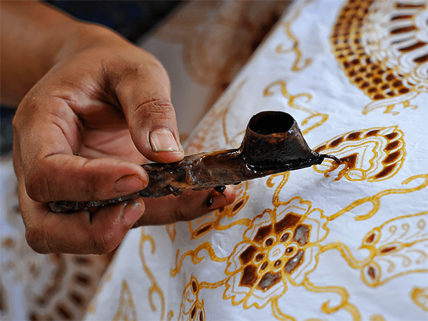 The canting tool used to lay wax on cloth during batik printmaking. Photo credit: Adwindo
